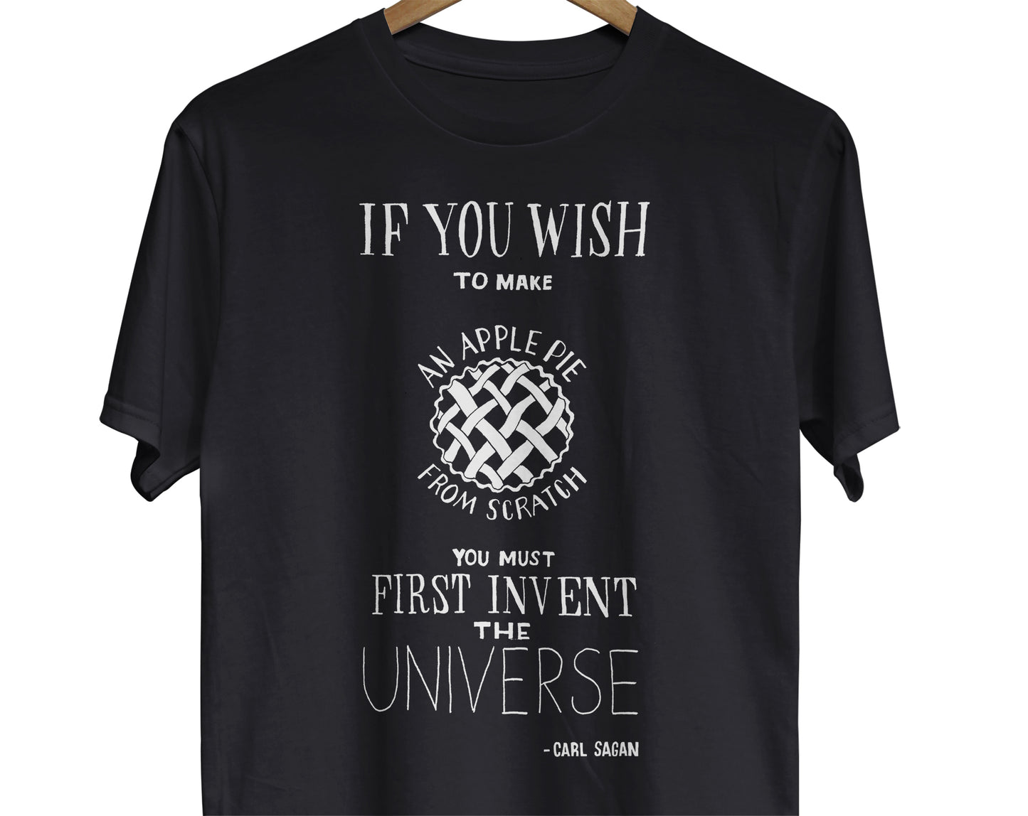 Carl Sagan-inspired T-Shirt: A visually appealing illustration of a pie with a quote by Carl Sagan, 'If you wish to make an apple pie from scratch, you must first invent the universe.' The pie represents the concept of creation and the quote reflects the idea that everything we create is built upon the foundation of the universe.