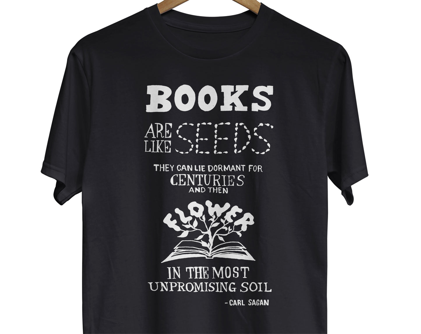 Science Quote T-Shirt:with a design featuring a hand-lettered sketch and illustrated quote by Carl Sagan that reads, 'Books are like seeds. They can lie dormant for centuries and then flower in the most unpromising soil.' For book lovers, librarians, and science teachers