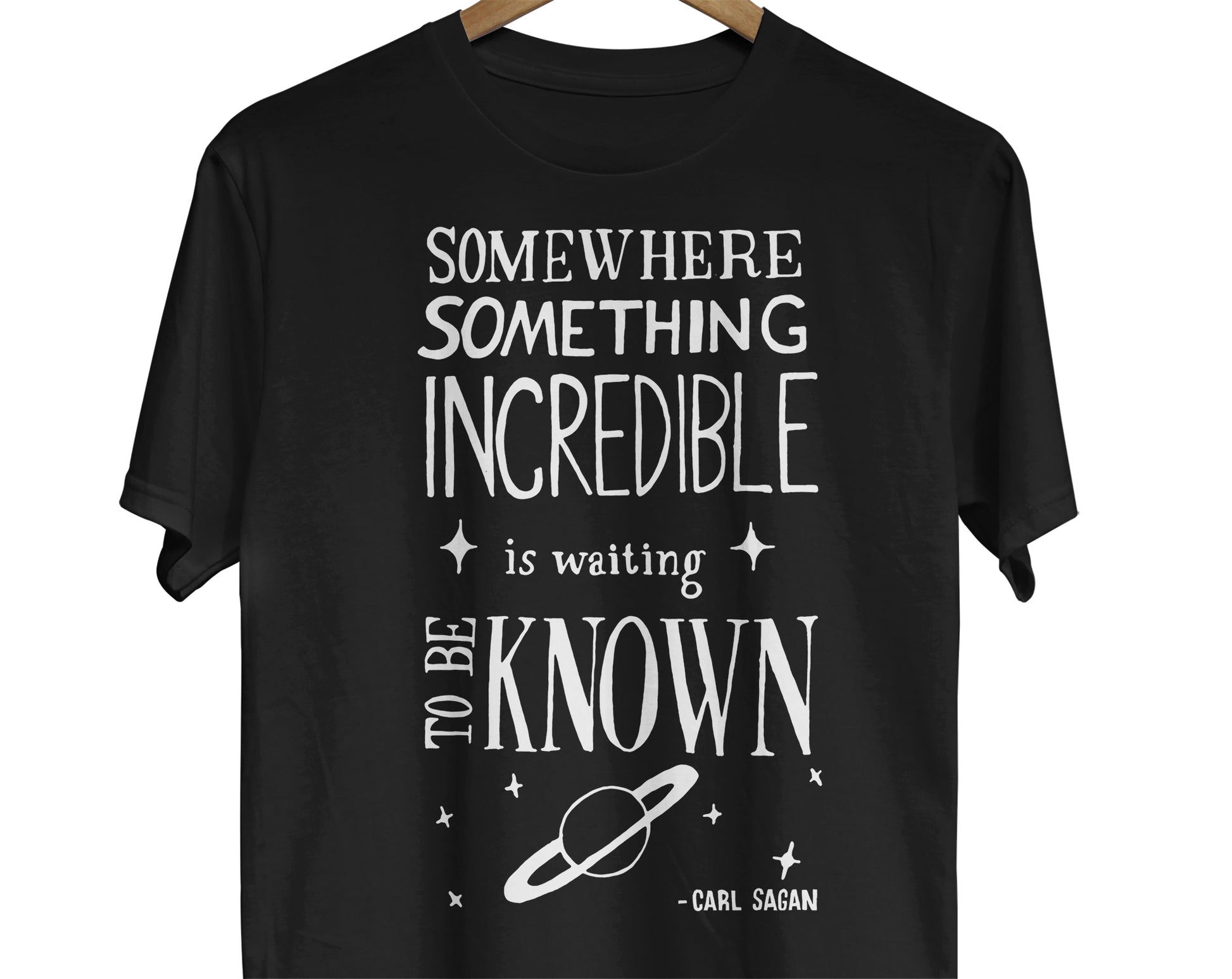 Carl Sagan Science Quote T-Shirt: A visually captivating design featuring a hand-lettered quote by Carl Sagan that reads, 'Somewhere, something incredible is waiting to be known.' The quote is beautifully presented with artistic lettering, evoking a sense of wonder and inspiration.