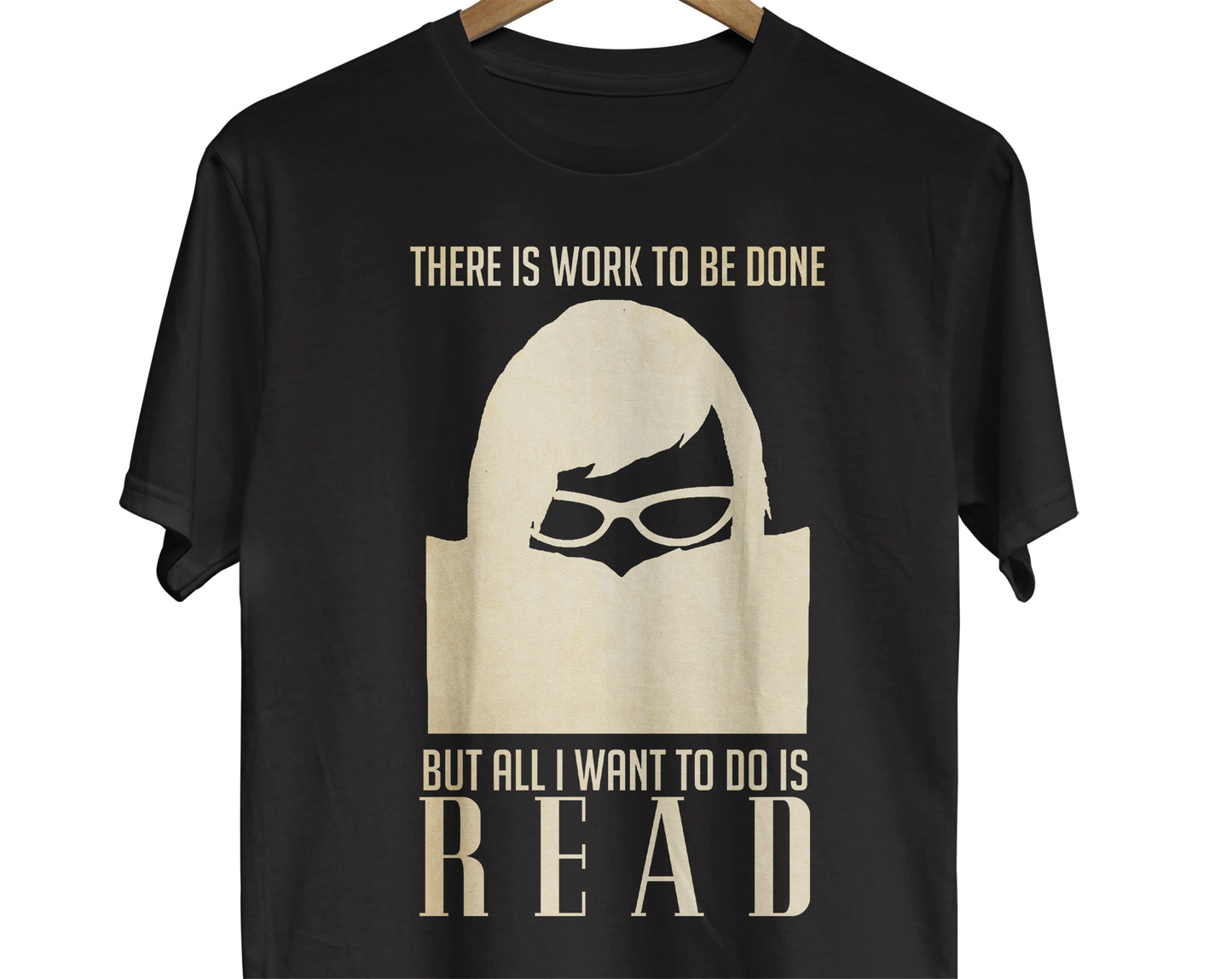A Bookworm t-shirt featuring a silhouette of a reader immersed in a book, accompanied by the text "There Is Work To Be Done But All I Want to Do Is Read". 